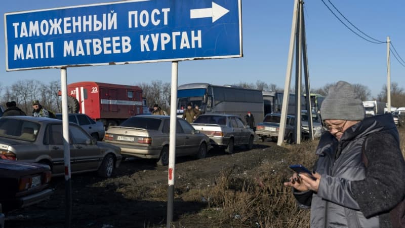 Une-femme-regarde-son-telephone-mobile-pres-d-une-file-d-attente-de-voitures-a-la-frontiere-entre-l-Ukraine-et-la-Russie-au-point-de-passage-d-Avilo-Uspenka-le-19-fevrier-2022-1270805