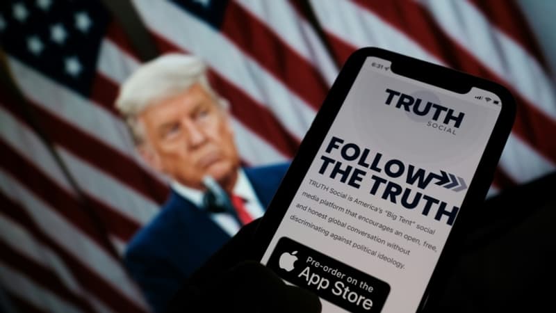 Une-personne-montre-l-application-Truth-social-sur-son-telephone-devant-un-fond-d-ecran-de-Donald-Trump-a-Los-Angeles-le-20-octobre-2021-1151061