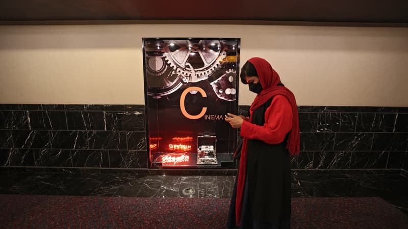 Une-femme-passe-devant-l-affiche-du-festival-du-court-metrage-de-Teheran-le-19-octobre-2021-1678835
