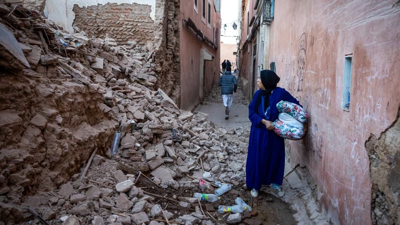 Une-femme-passe-dans-les-decombres-d-une-rue-de-Marrakech-au-Maroc-apres-le-seisme-1703122