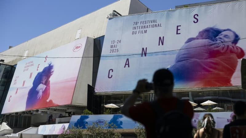 Un-pieton-prend-une-photo-des-affiches-de-la-78e-edition-du-Festival-de-Cannes-devant-le-Palais-des-Festivals-a-Cannes-dans-le-sud-de-la-France-le-12-mai-2025-2080296
